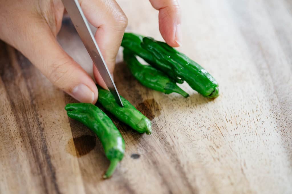 Poking shishito peppers with a knife