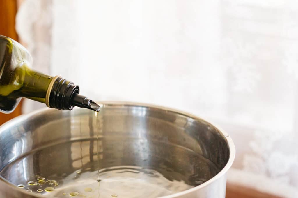 Adding oil to a cooking pot