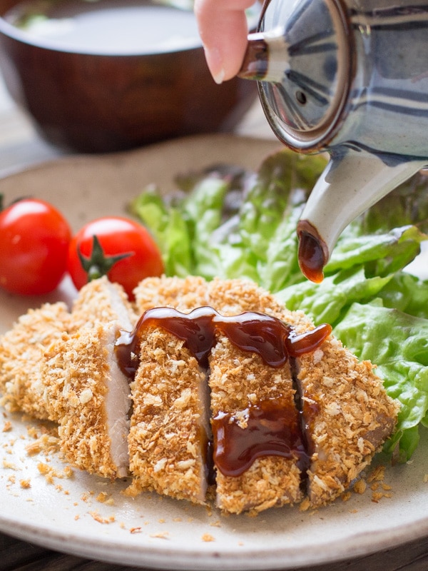Pouring sauce on top of Baked Tonkatsu- Japanese Panko Crumbed Pork Cutlet 