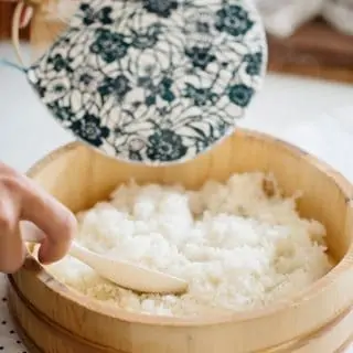 making sushi rice in a wooden tub with a Japanese fan Uchiwa