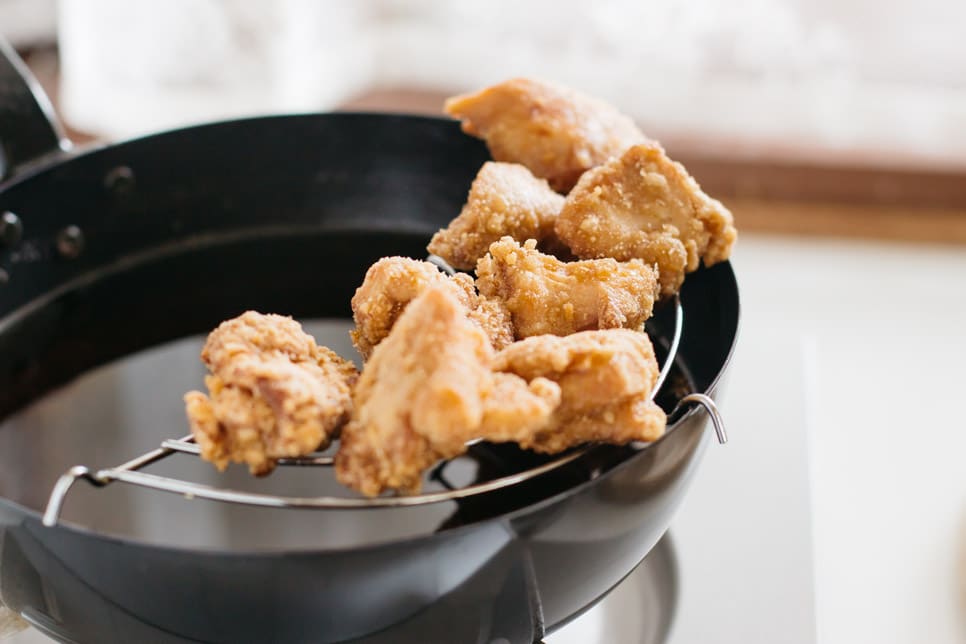 chicken pieces deep fried and drained on a lack