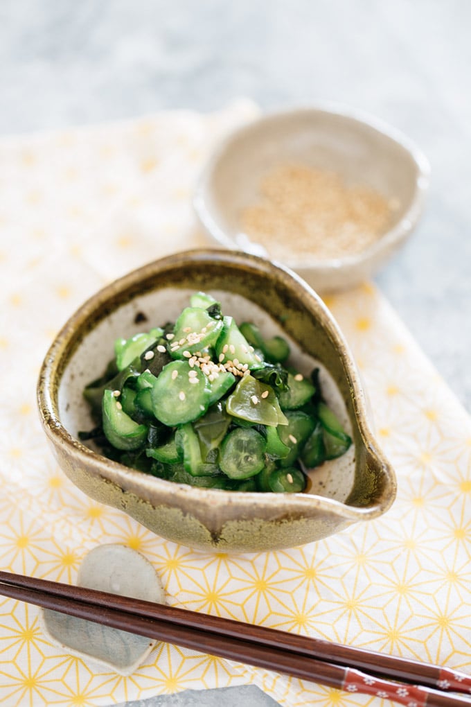Japanese cucumber salad served in a small Japanese pottery bowl with a pair of chopsticks.