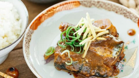 saba misoni served on a Japanese antique plate with a pair of chopsticks and a bowl of rice