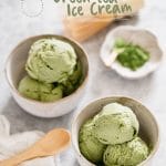 Green tea ice cream in two bowls with a wooden spoon and a small bowl of green tea powder in back ground