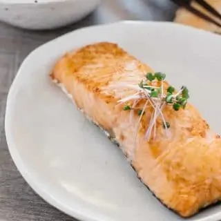 a piece of grilled slated salmon on a white plate