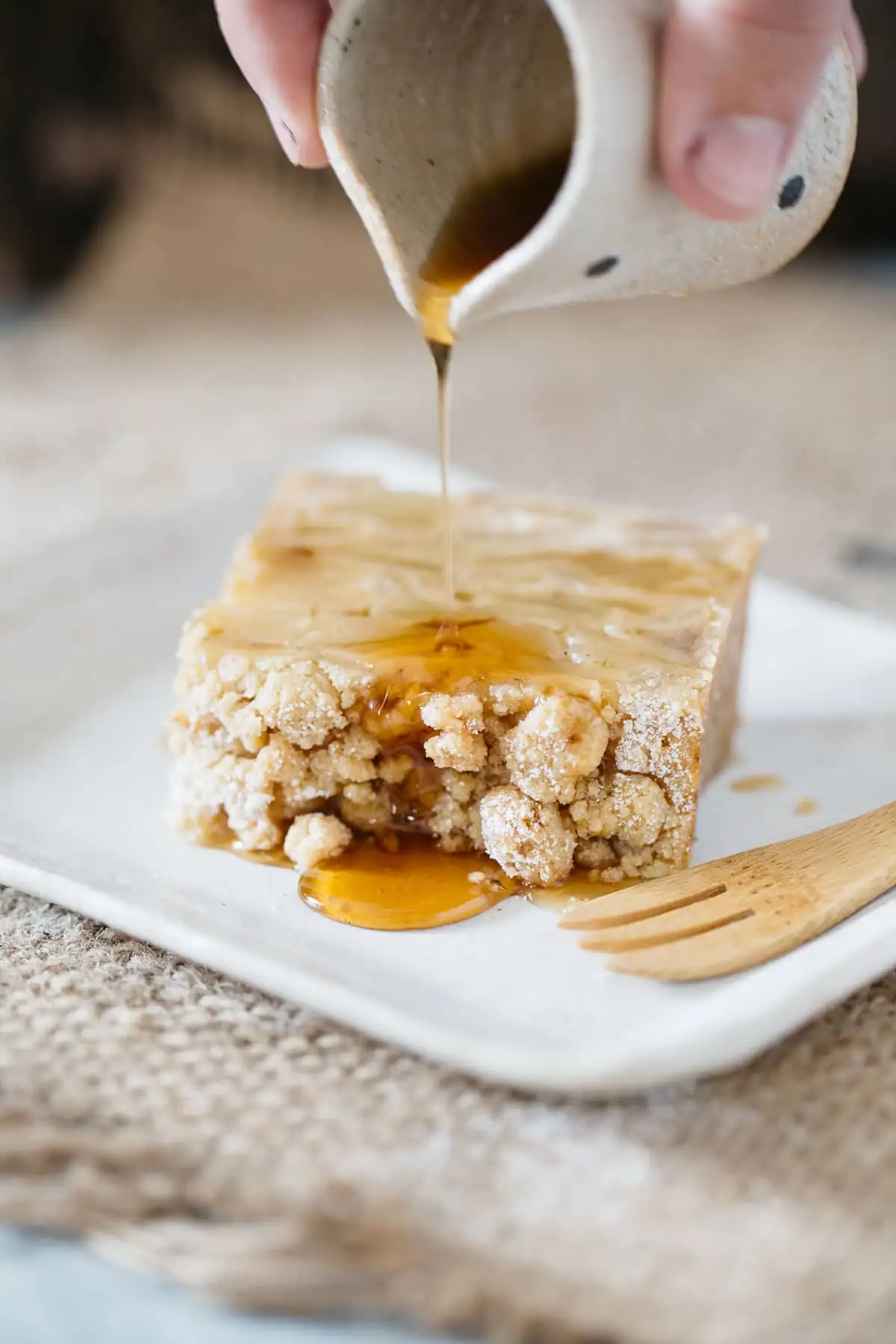 maple syrup poured over invisible apple crumble cake