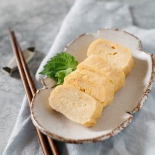 4 pieces of Japanese rolled egg Tamagoyaki are served on a oval plate