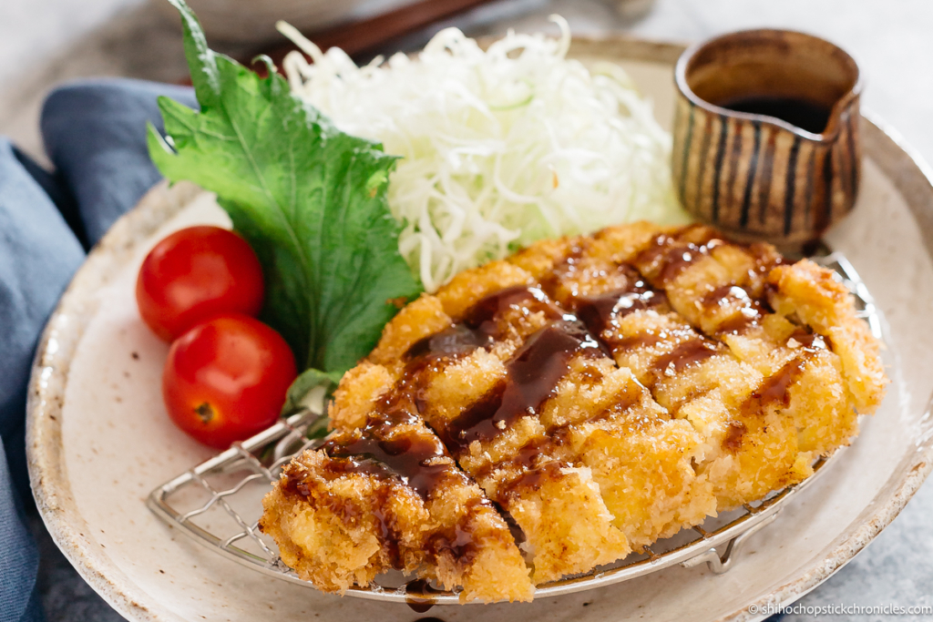 tonkatsu served with shredded cabbage and tonkatsu sauce drizzled over  