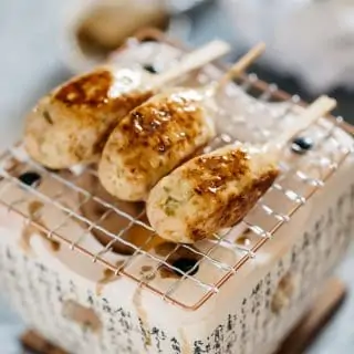 3 Tsukune Chicken meatball on skewers over an individual Japanese style grill