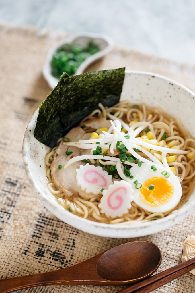 Shoyu Ramen served in a large white ramen noodle bowl with nori seaweed stick out