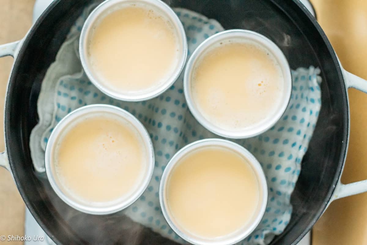 Creamy Japanese custard pudding served in four cups on a steaming tray.