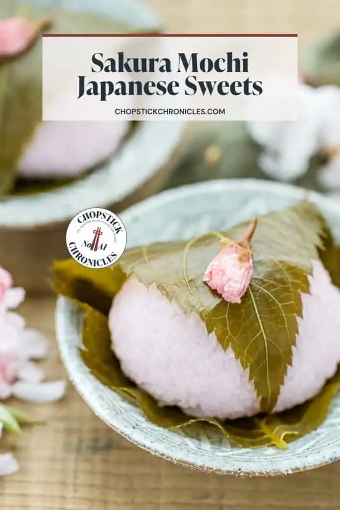 sakura mochi served on a small plate with sakura cherry blossoms with text overlay for pinterest