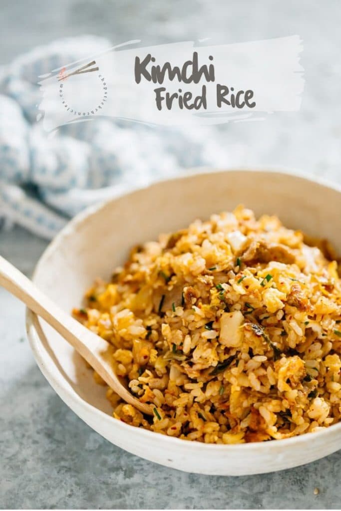 Kimchi fried rice served in a shallow round bowl with a wooden spoon