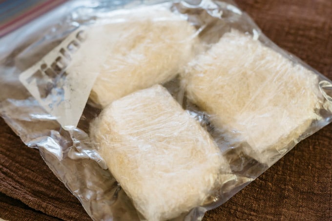 three korokke wrapped in cling wrap before deep frying for storing in freezer
