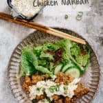 chicken nanban served on a round plate with green salad with a bowl of tartar sauce