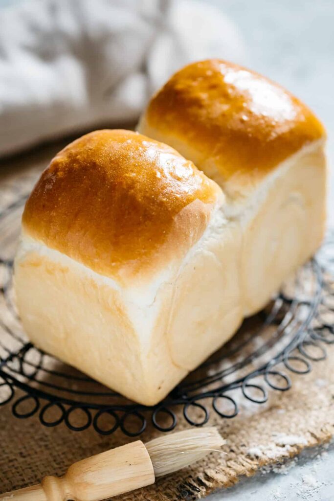 a freshly baked shokupan Japanese milk bread loaf on a cooling rack