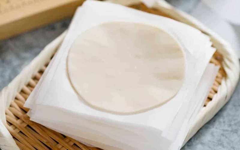 a stack of gyoza wrappers on a bamboo tray