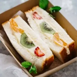 2 pieces of Fruit Sandwich in a takeaway cardboard container