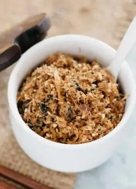 Furikake is in a bowl with a small ceramic spoon