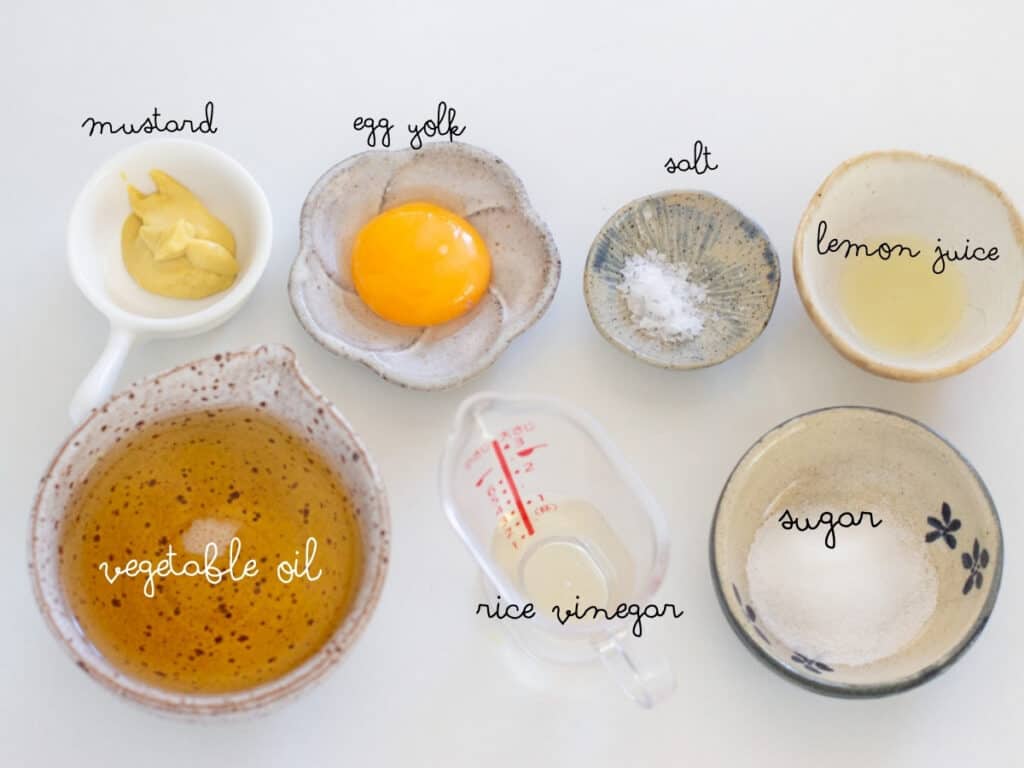 an egg yolk, dijon mustard, oil, salt, lemon juice and sugar in small bowls
