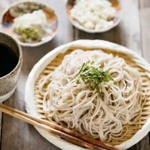 Cold soba noodles served on a bamboo strainer topped with shredded nori seaweed