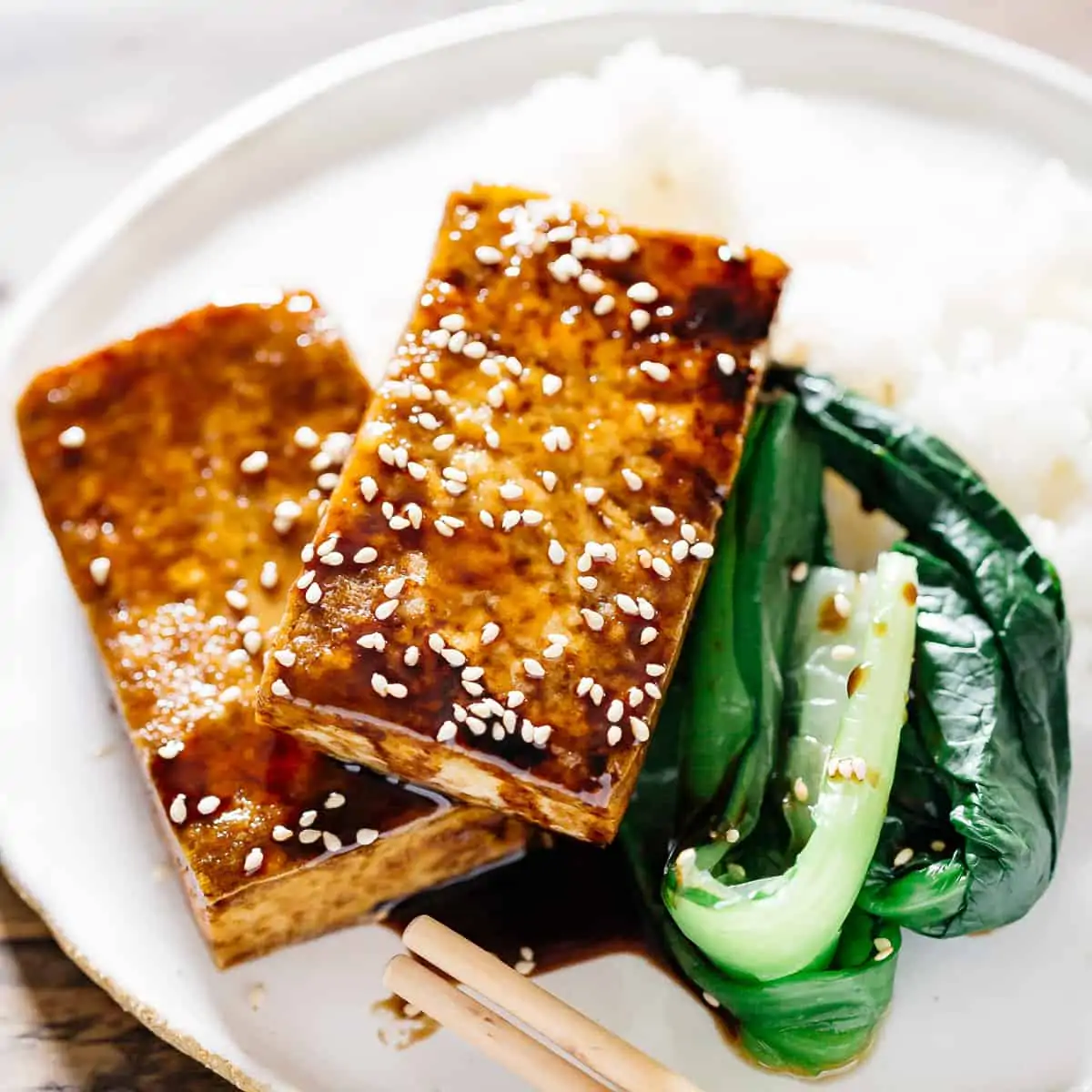 two piece of Easy crispy Japanese tofu steak served with green veggies and a plain cooked rice