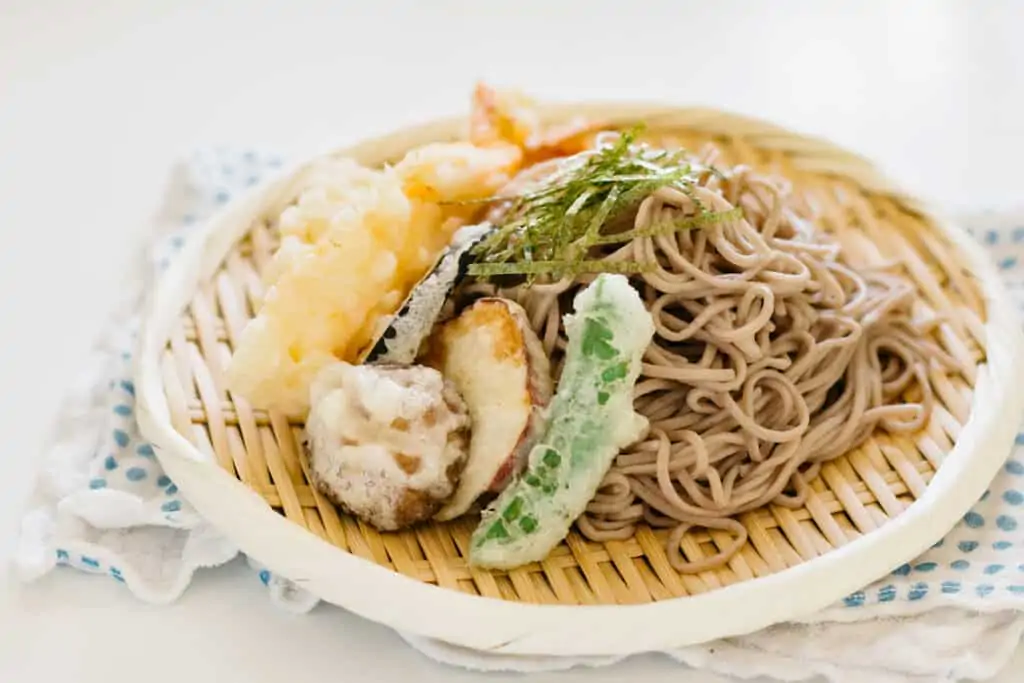 prawn tempura and vegetable tempura served on the bed of cold soba noodle