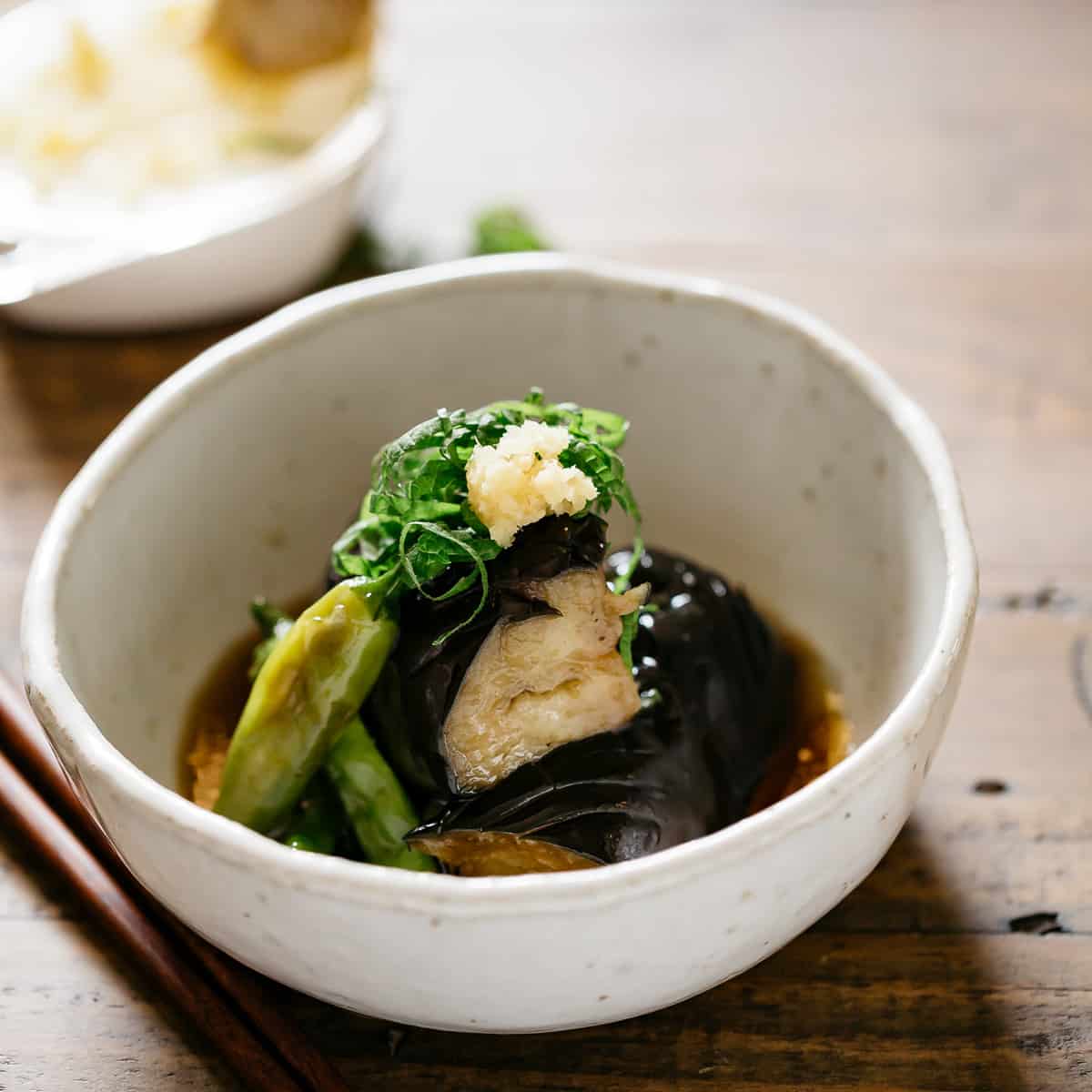 Japanese eggplant recipe agebitashi is served in a round shallow bowl