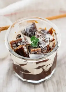 coffee jelly served in a glass with wooden spoon in background