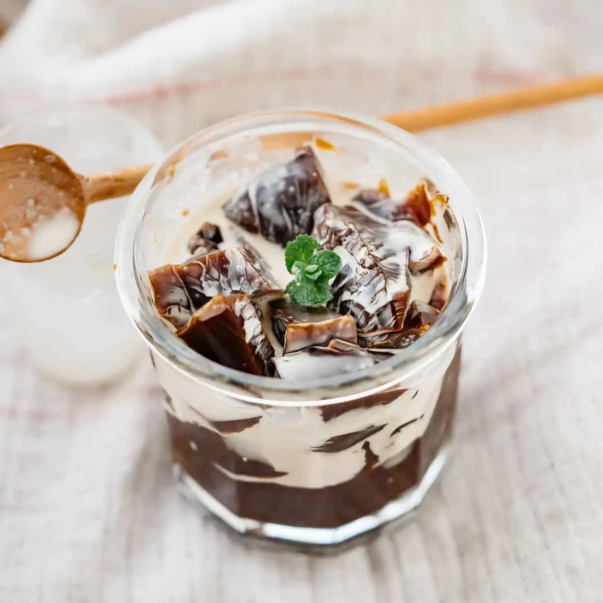 coffee jelly served in a glass with wooden spoon in background