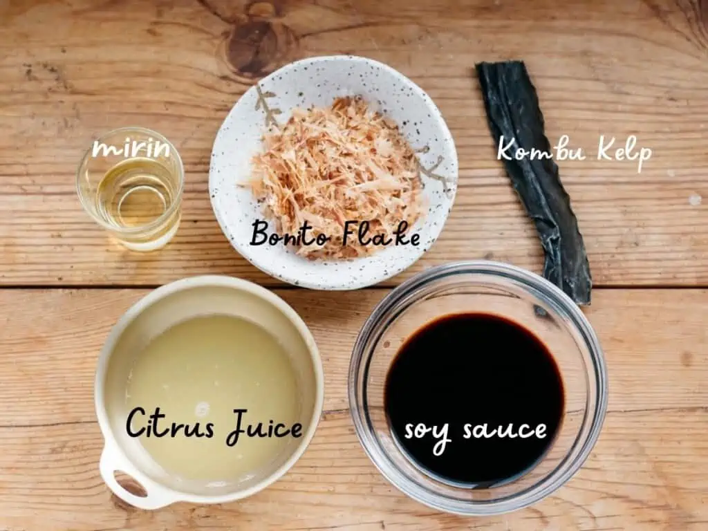 citrus juice, soy sauce and mirin in bowls and bonito flake and a strip of kombu kelp