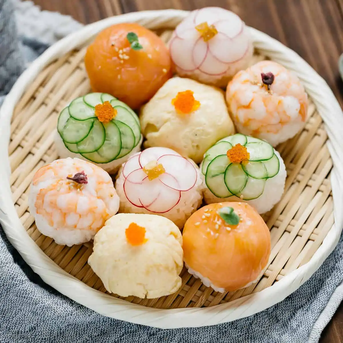 10 temari sushi balls are served on a round bamboo tray