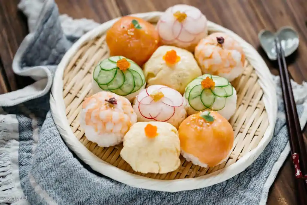 10 temari sushi served on a round bamboo tray