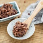 naturally sweet fermented red bean paste on a wooden spoon and red bean paste in a square bowl in background