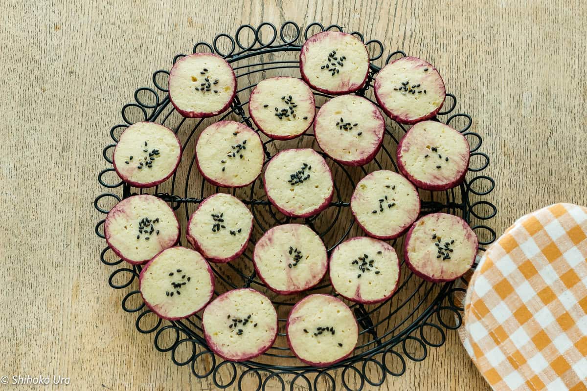 Japanese sweet potato cookies with black sesame seeds on cooling rack.
