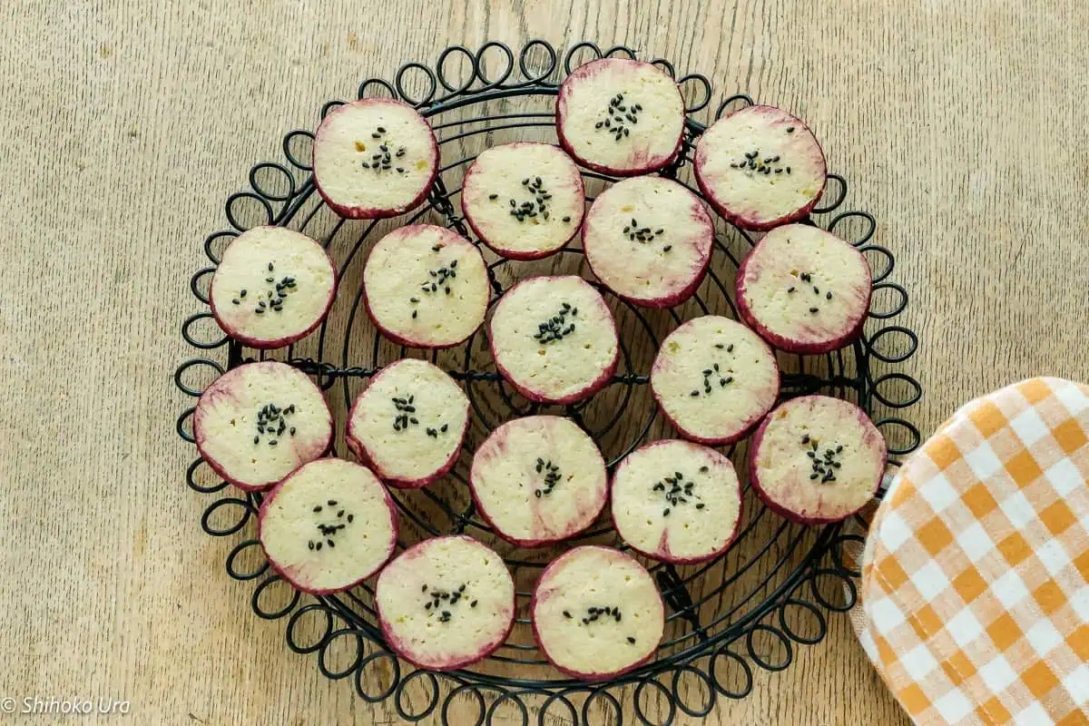 Japanese sweet potato cookies with black sesame seeds on cooling rack.